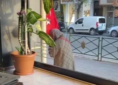 Eskişehir’de bir kadının işletmenin önünde asılı olan Türk bayrağını defalarca